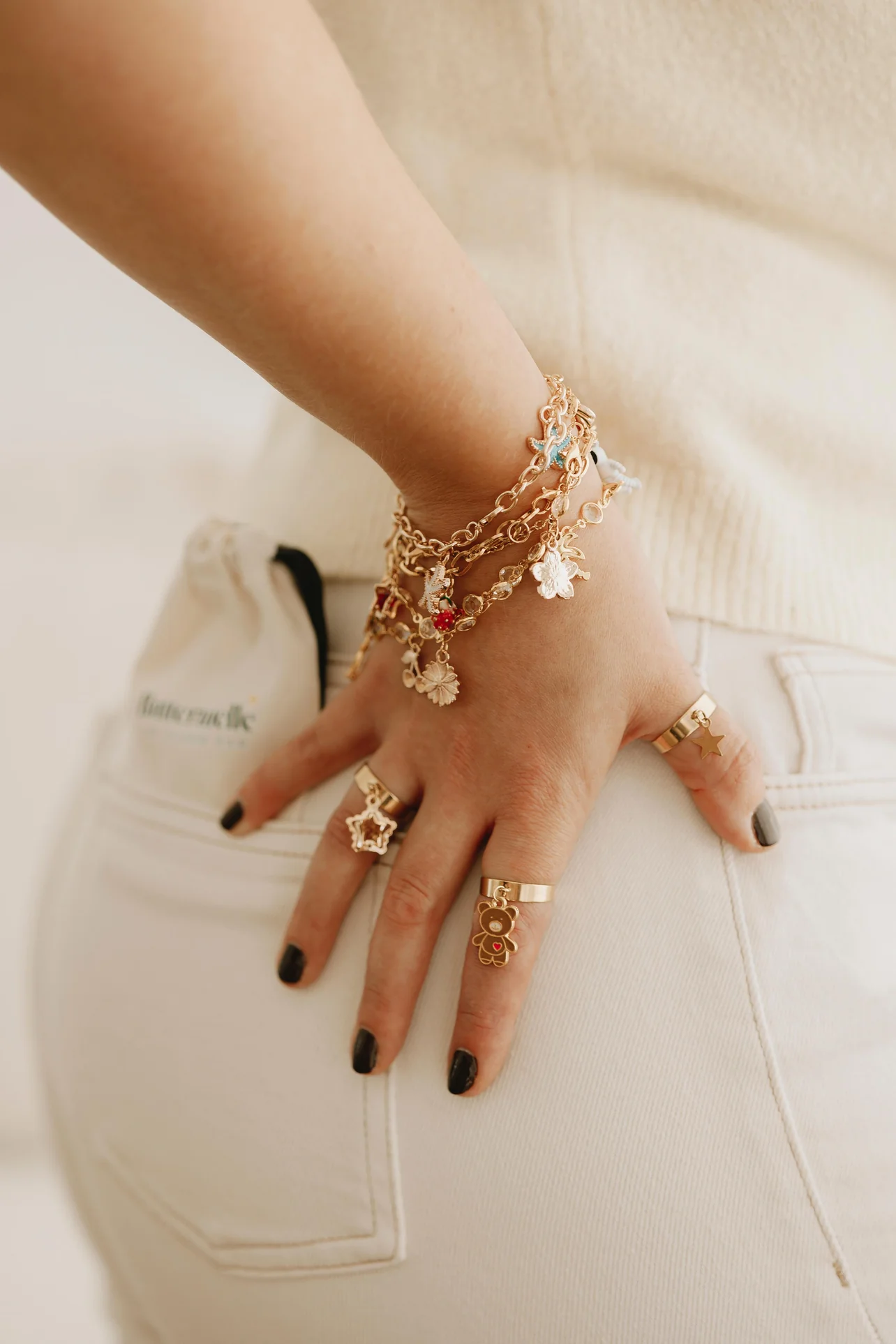 Buttermelle charm bracelets stacked on a wrist