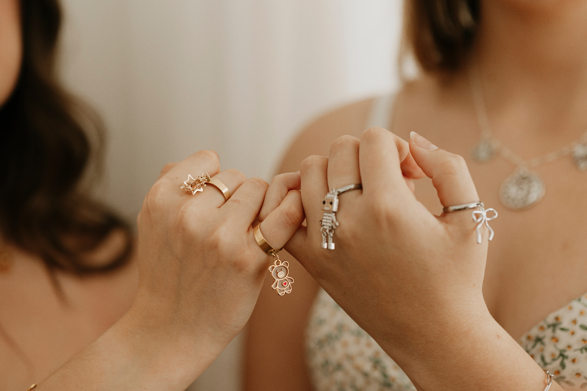 Two people comparing their charm rings and bracelets