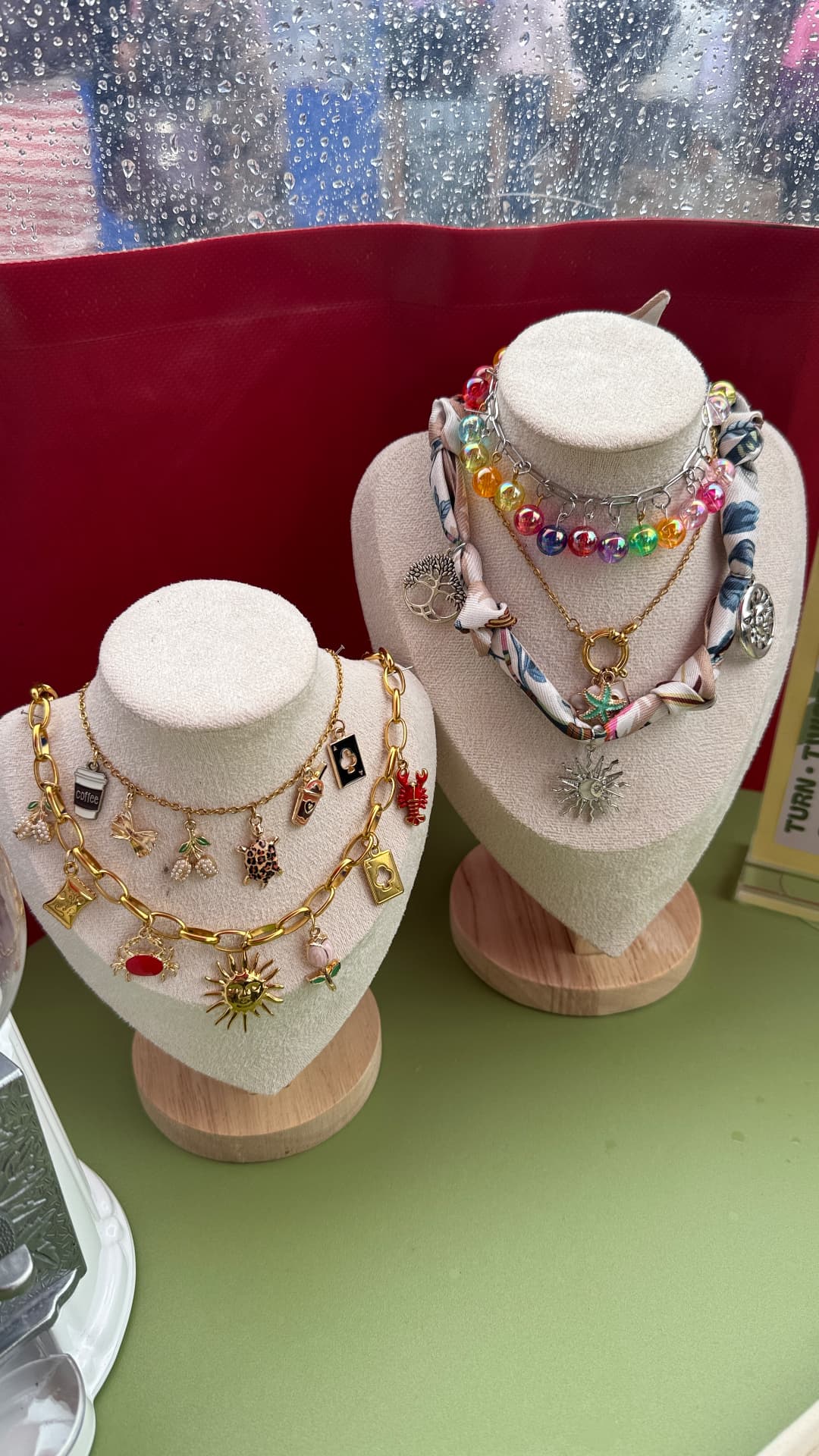 Charm necklaces displayed on busts